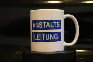 Weiße Tasse mit Spruch "ANSTALTSLEITUNG"